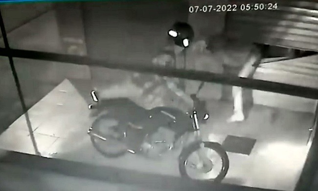 Indivíduo saindo pela porta arrombada