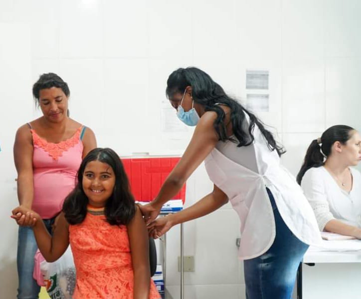 Marine Meireles, ao lado da mãe, foi a primeira criança a receber a imunização da campanha