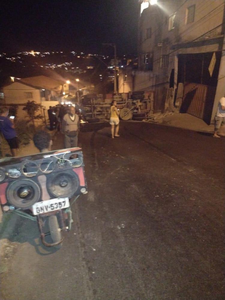 Caminhão carregado com brita tomba, atinge muro e deixa duas pessoas feridas em Santa Luzia